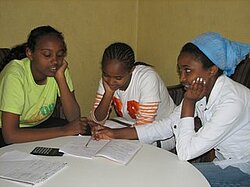 Sélomé soutient et encourage ses deux jeunes soeurs dans leur travail scolaire.