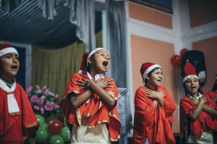 les enfants parrainés chantent des chants de Noël