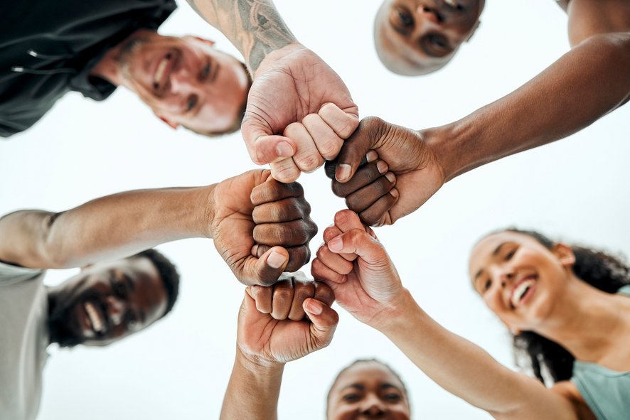 Groupe de personnes réunissant leur poings en signe d'unité. 