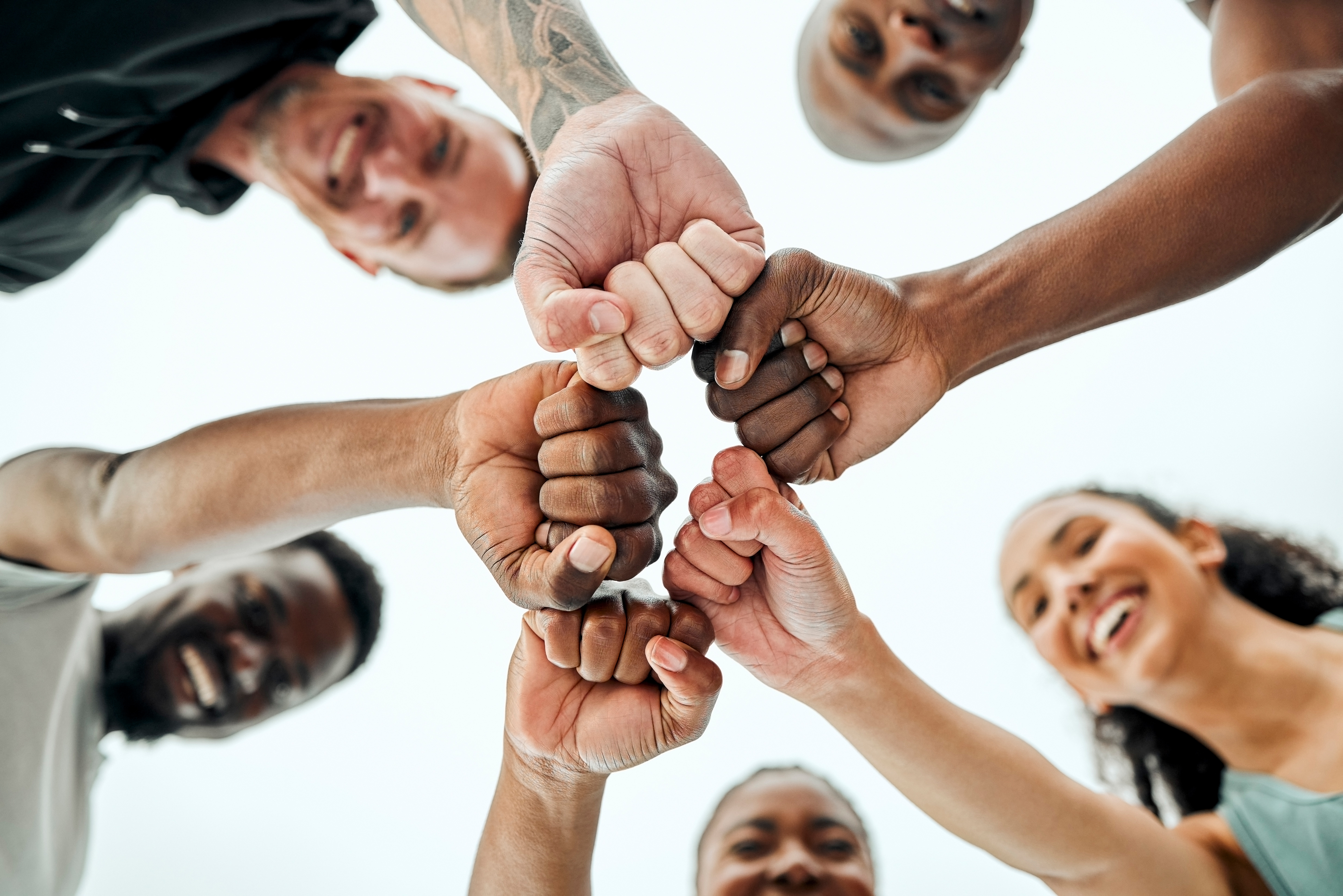 Groupe de personnes réunissant leur poings en signe d'unité. 